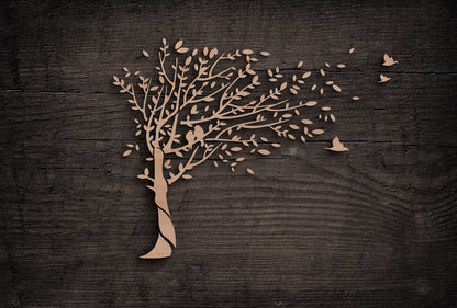 Wooden cutout of a tree with birds on a dark wooden background