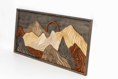 Wooden wall art with mountain design on a white background